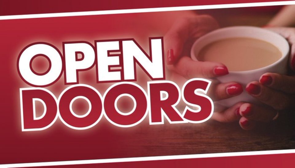 Text reads Open Doors- hands curled around cup of tea